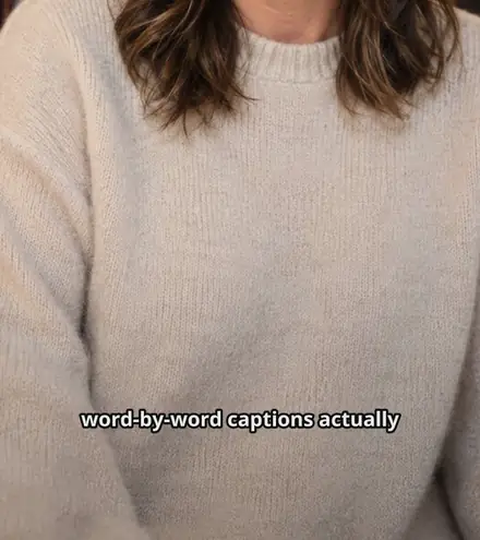 A frame of captioned video in the Clean style, with the words "word-by-word captions actually" across the lower third and the current word highlighted